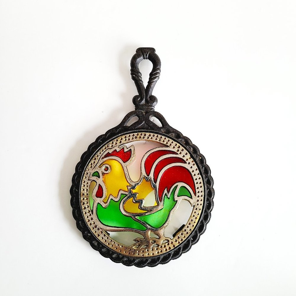 Vintage cast iron trivet with metal and plastic rooster.